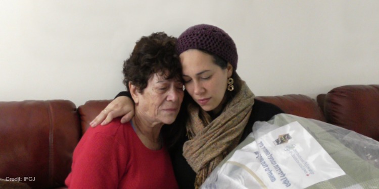 Yael Eckstein sitting with a woman in a red sweater on a couch.