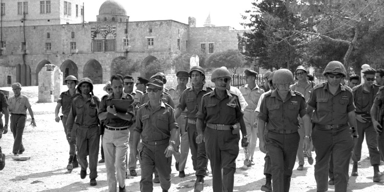 Black and white image of several soldiers walking towards the camera.