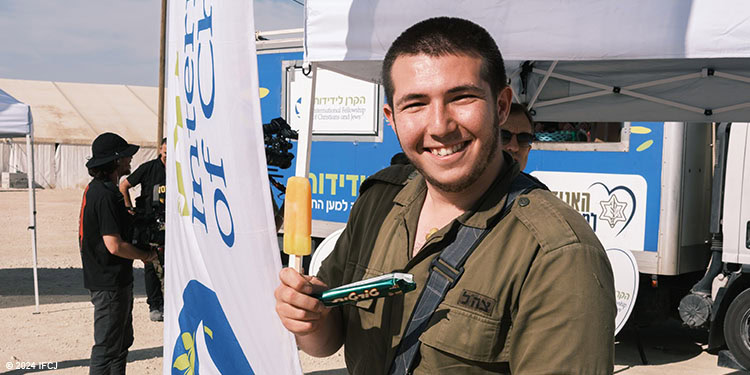 Soldier in uniform in front of one of the Fellowship's hospitality vehicles