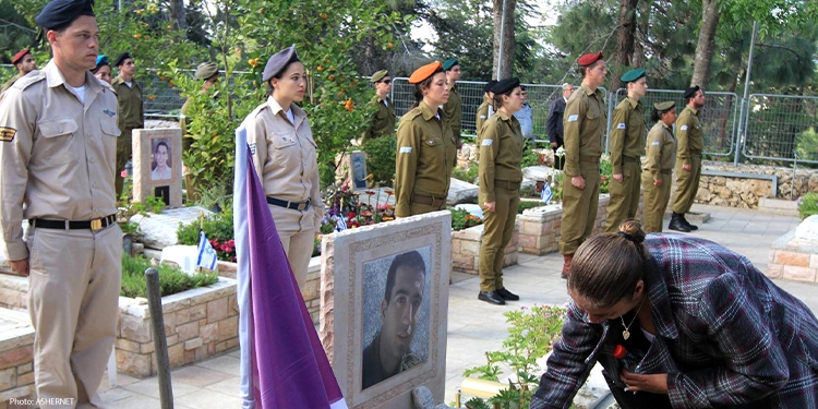 Soldiers lined up in front of a cemetery.