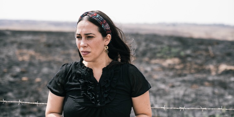 Yael Eckstein standing in burnt fields in Southern Israel