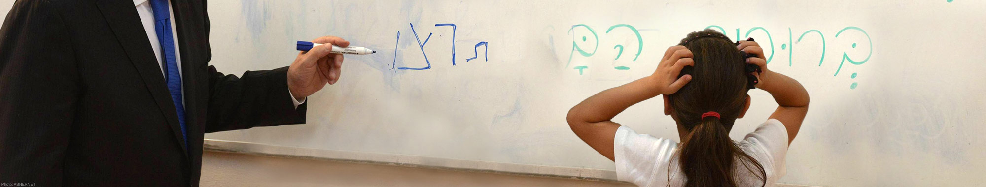 Young girl holding her head while looking at a whiteboard confused.