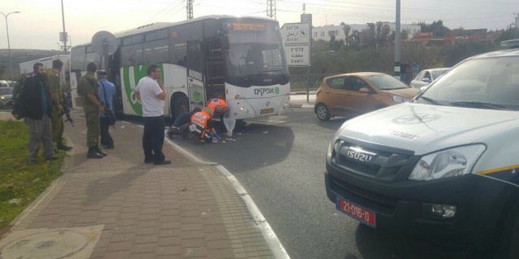 Ambulance and soldiers around a bus as they help aid the victims of a stabbing.