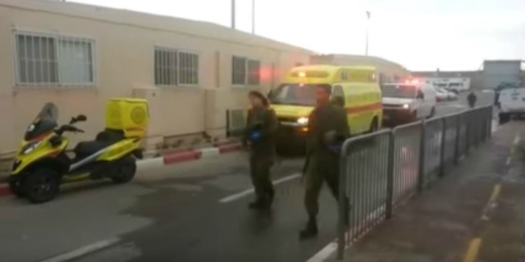 Two IDF soldiers walking with two emergency trucks behind them.