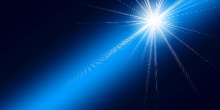 A star shining brightly while casting a blue light in a black sky.