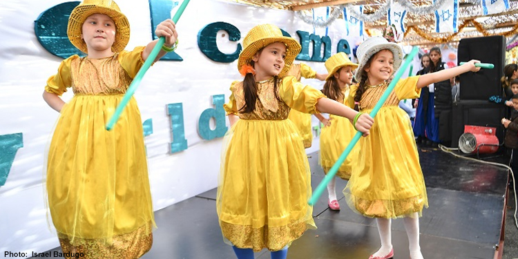 Young girls performing a song and dance for Sukkot celebration