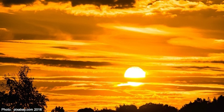 The sun coming through the clouds right at sunrise.