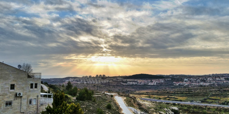 Sunrise over the land and buildings of Israel.