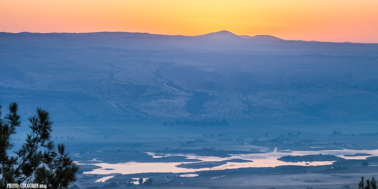 Sunrise coming up behind mountains in the distance.