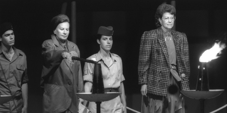 Two women and two soldiers standing by the beacons of Israel's 40th anniversary celebration.