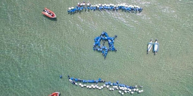 An aerial view of surfers forming the Star of David with their boards.