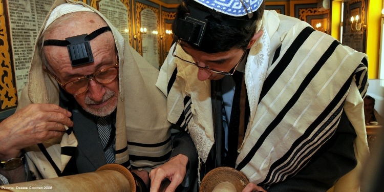 Teenage boy studying the Torah with an elderly man in Romania.
