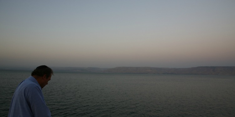 Rabbi Eckstein looking ahead at a large body of water with mountains behind it.