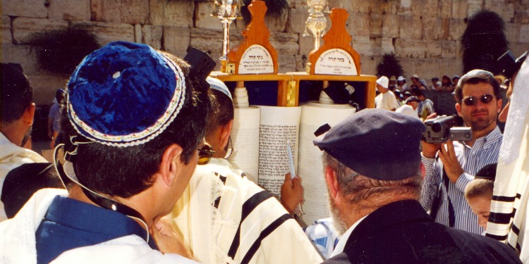 Men facing the Torah scroll that was brought to the Western Wall.
