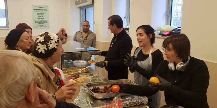 Volunteers passing out food to elderly Jewish people.