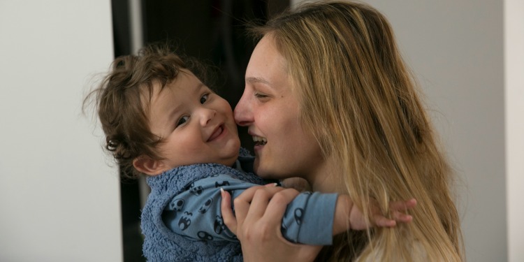 Mother holding child and smiling