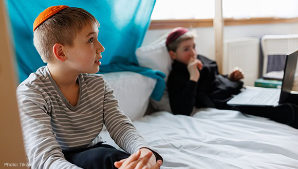 Two boys sitting on a bed