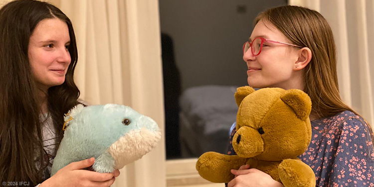 Two girls holding teddy bears