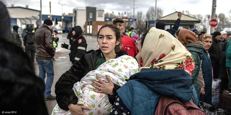 Woman holding infant crossing Ukraine border