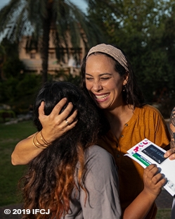 The Third Pillar- Tezedakah- Yael Eckstein smiling and hugging woman
