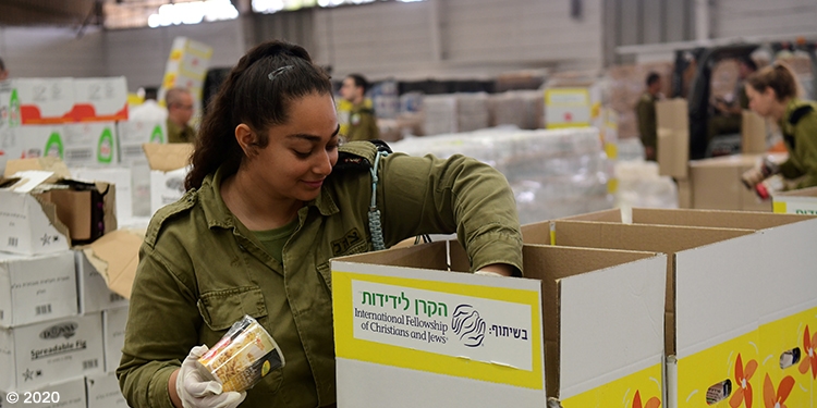 Soldier helping to put together an IFCJ branded food box.