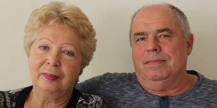 Liudmyla and Volodymyr, IFCJ recipients smiling softly at the camera while sitting together.