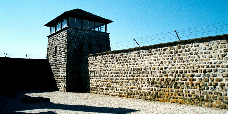 Watchtower with a fence at the top during the daytime.