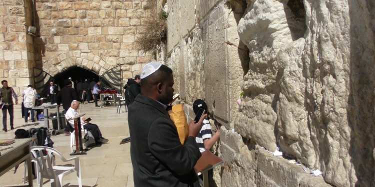 A man with a kippah standing near the Western Wall.