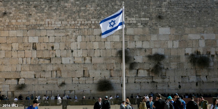 Israeli flag flying in the air at the Western Wall.