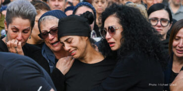 Woman in mourning while her two friends comfort her.