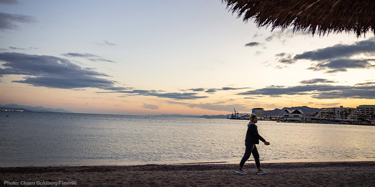 Woman walking along the beach in the southern Israeli city of Eilat