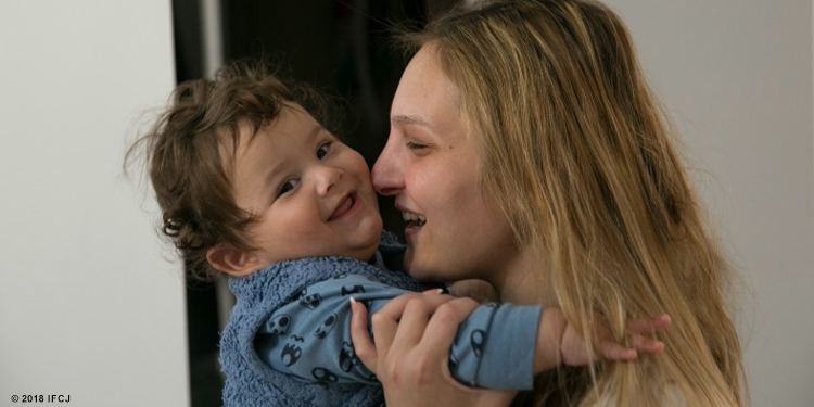 Mother and child smiling at eachother.