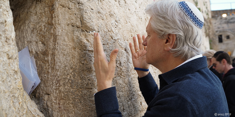 Bishop Lanier with his hands in front of him in prayer at the Western Wall.