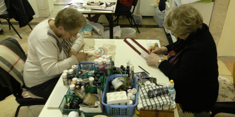 Two women sitting at a table making crafts during Yad LaKashish.