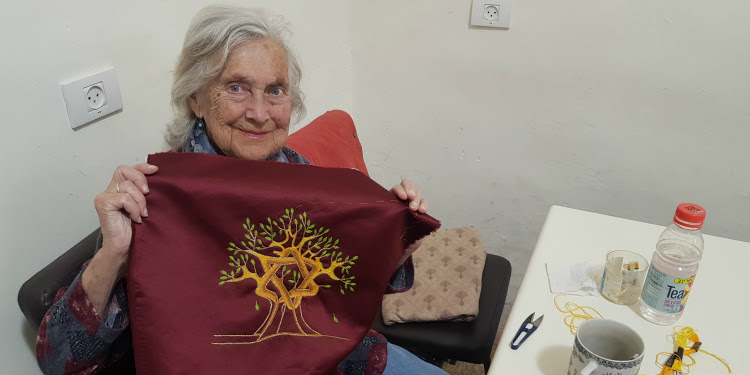 Yad Lakashish, an IFCJ recipient holding up a piece of cloth.