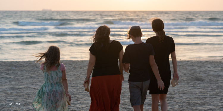 Yael Eckstein and children on beach, contemplative ahead of High Holy Days