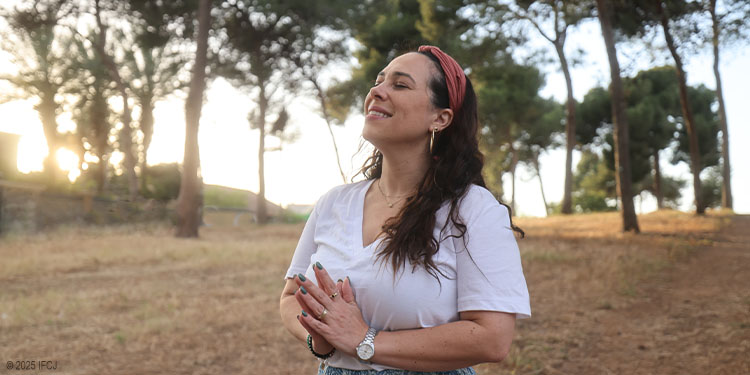 Yael Eckstein praying outdoors by trees at sunset