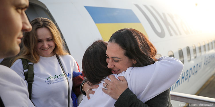 Yael Eckstein happily hugs passengers exiting a plane