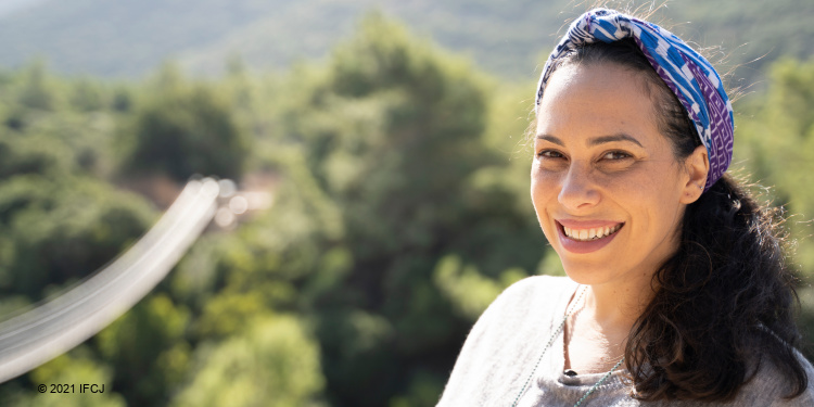 Yael smiling at the camera with Nesher Park behind her.