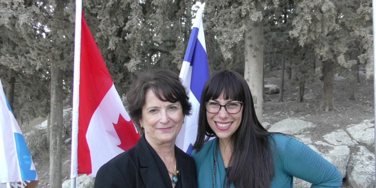 Yael Eckstein with the Canadian Ambassador in front of Canadian and Israeli flags.