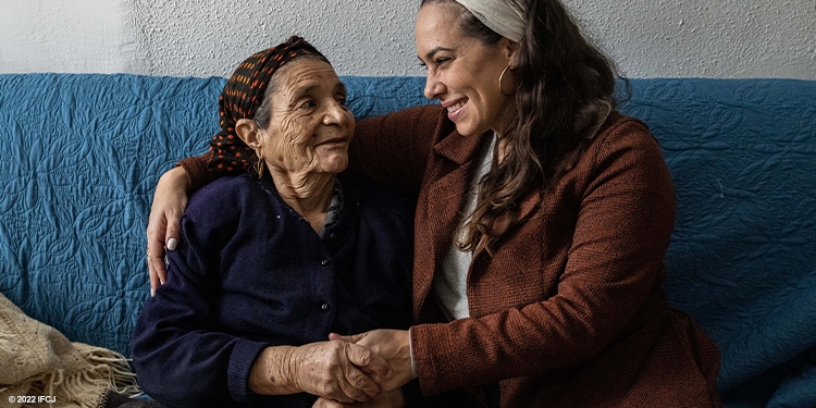 Yael sitting with elderly woman