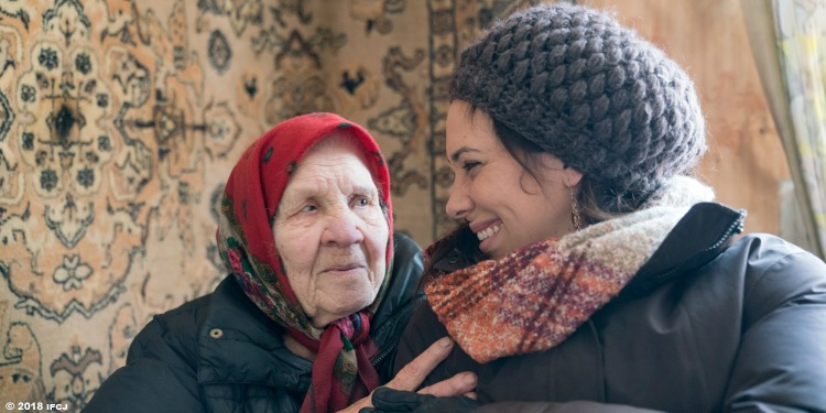 Yael Eckstein smiling at an Elderly Jewish Holocaust survivor.