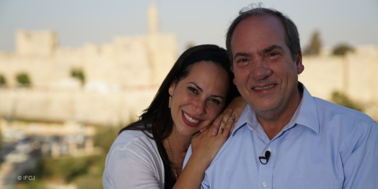 Yael laying her head on her father, Rabbi Eckstein's shoulder while Jerusalem is behind them.