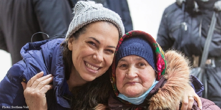 Yael smiling with elderly woman in Ukraine