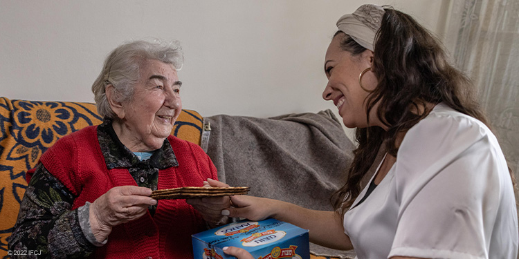 Yael sitting and smiling with elderly woman