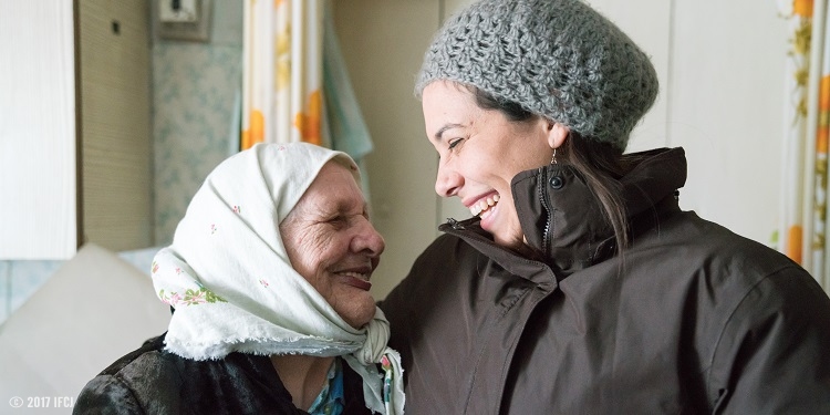 Yael Eckstein hugging an elderly wearing white head scarf wrap.