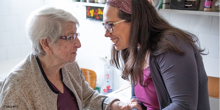 Yael Eckstein holding hands and smiling with an elderly Jewish woman.