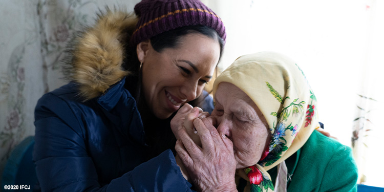 Yael and grateful elderly woman embracing.