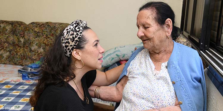 Yael Eckstein and elderly Jewish woman embracing.