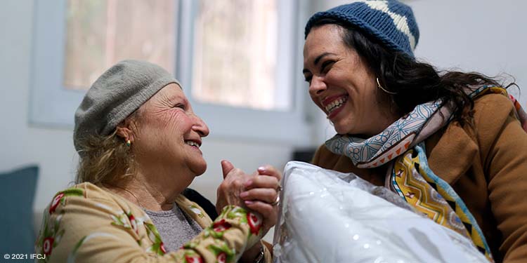 Yael Eckstein giving needy elderly woman a blanket